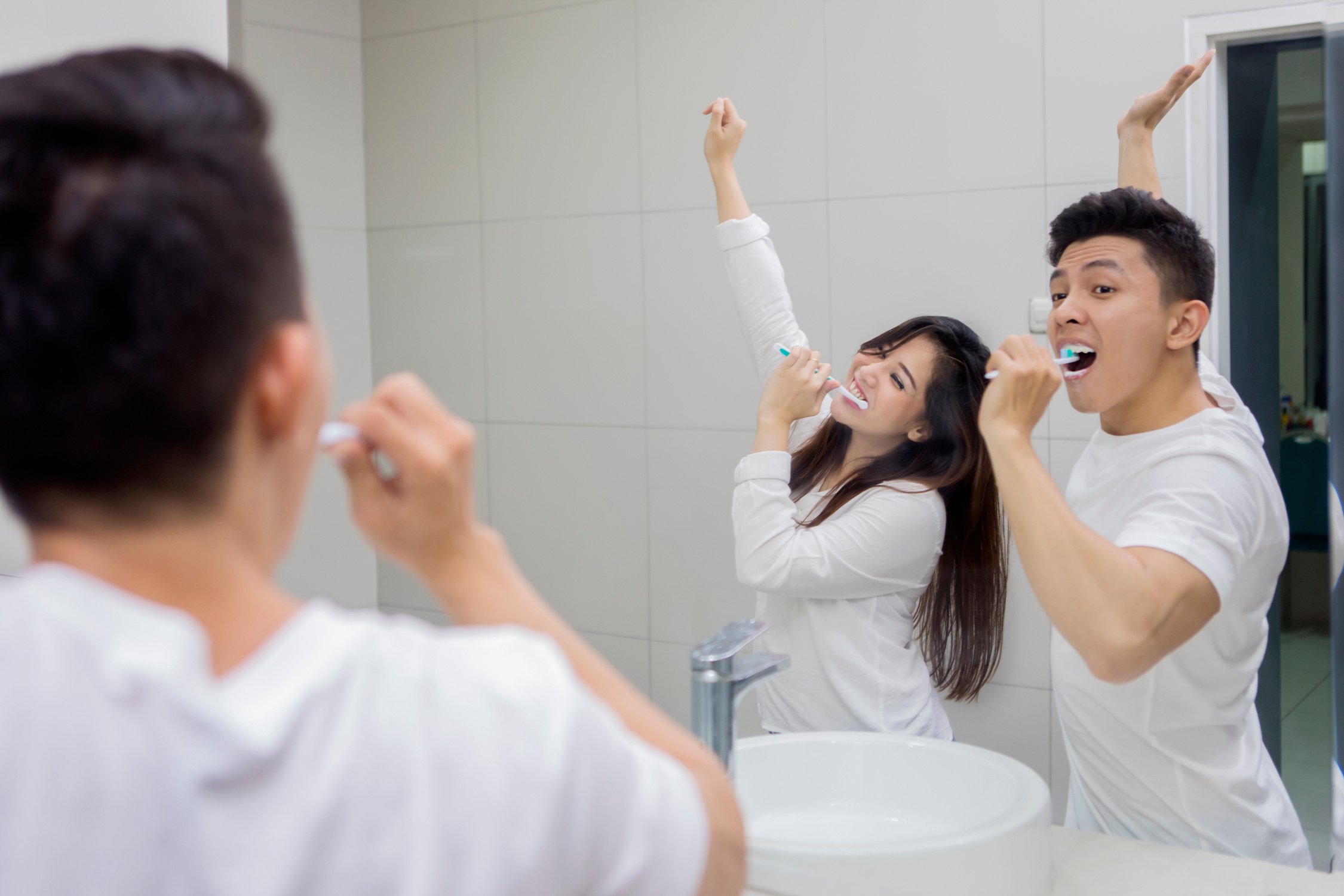 Happy Couple Brushing Teeth in the Bathroom